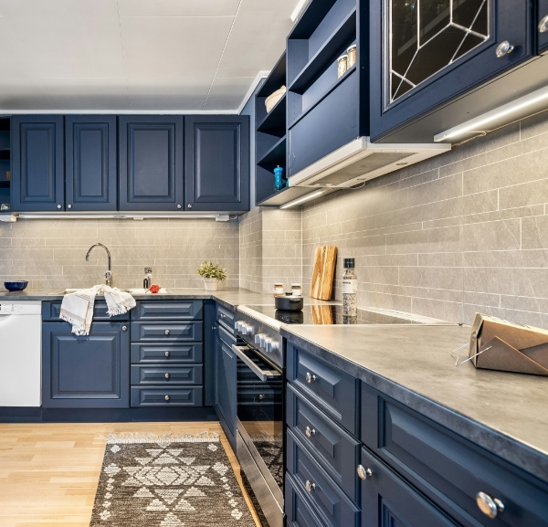 A spacious kitchen adorned with blue cabinets and a rich wooden floor, blending elegance with functionality.