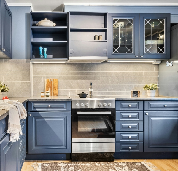 A modern kitchen featuring blue cabinets and a stove, showcasing a stylish and functional cooking space.