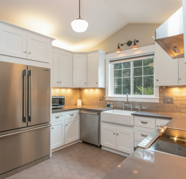 A stylish kitchen with stainless steel appliances and white cabinetry, showcasing a contemporary and inviting design.