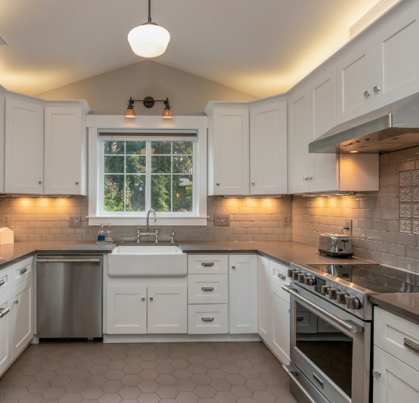 A modern kitchen featuring white cabinets and sleek stainless steel appliances, creating a bright and clean aesthetic.