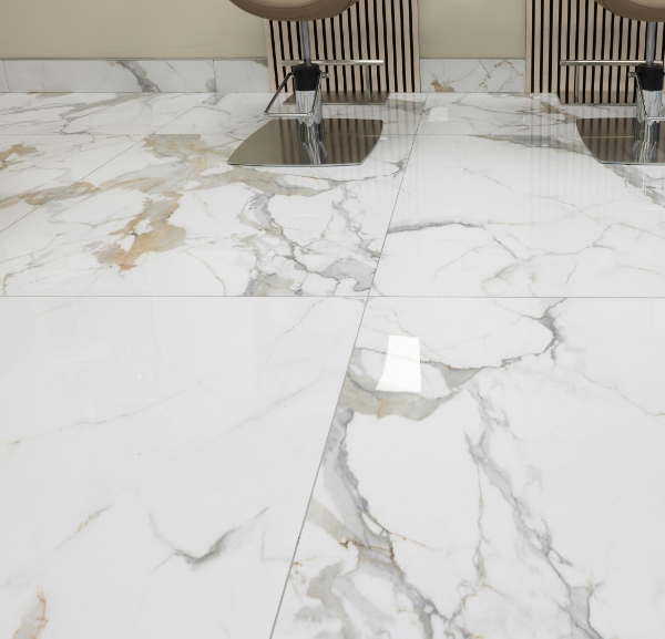 A marble floor featuring two chairs and a sink, creating a clean and elegant space.